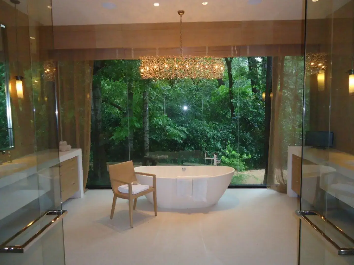 Modern bathroom with wooden blinds and custom drapery to provide privacy.