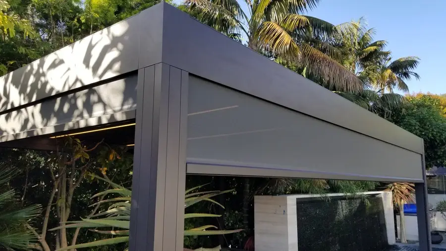 Raised exterior roller shade covering an outdoor living area.