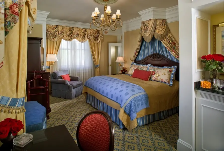 Custom gold drapery designed by BTX in a colorful bedroom at a hotel.