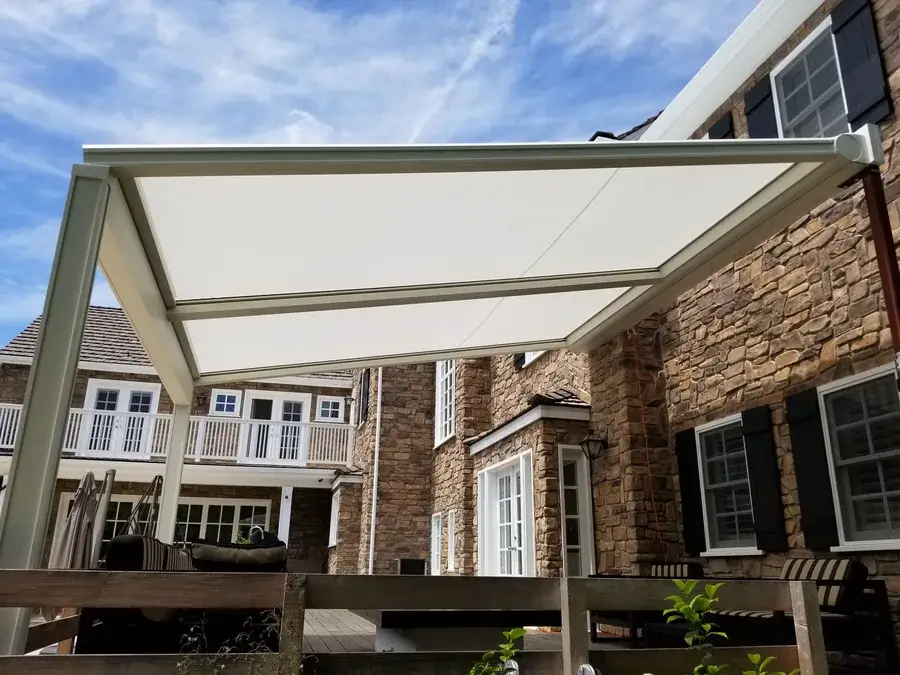 Custom patio roller shade installed on a brown brick home.