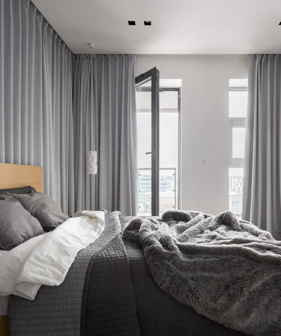 Grey-toned bedroom with custom grey full-wall drapes.