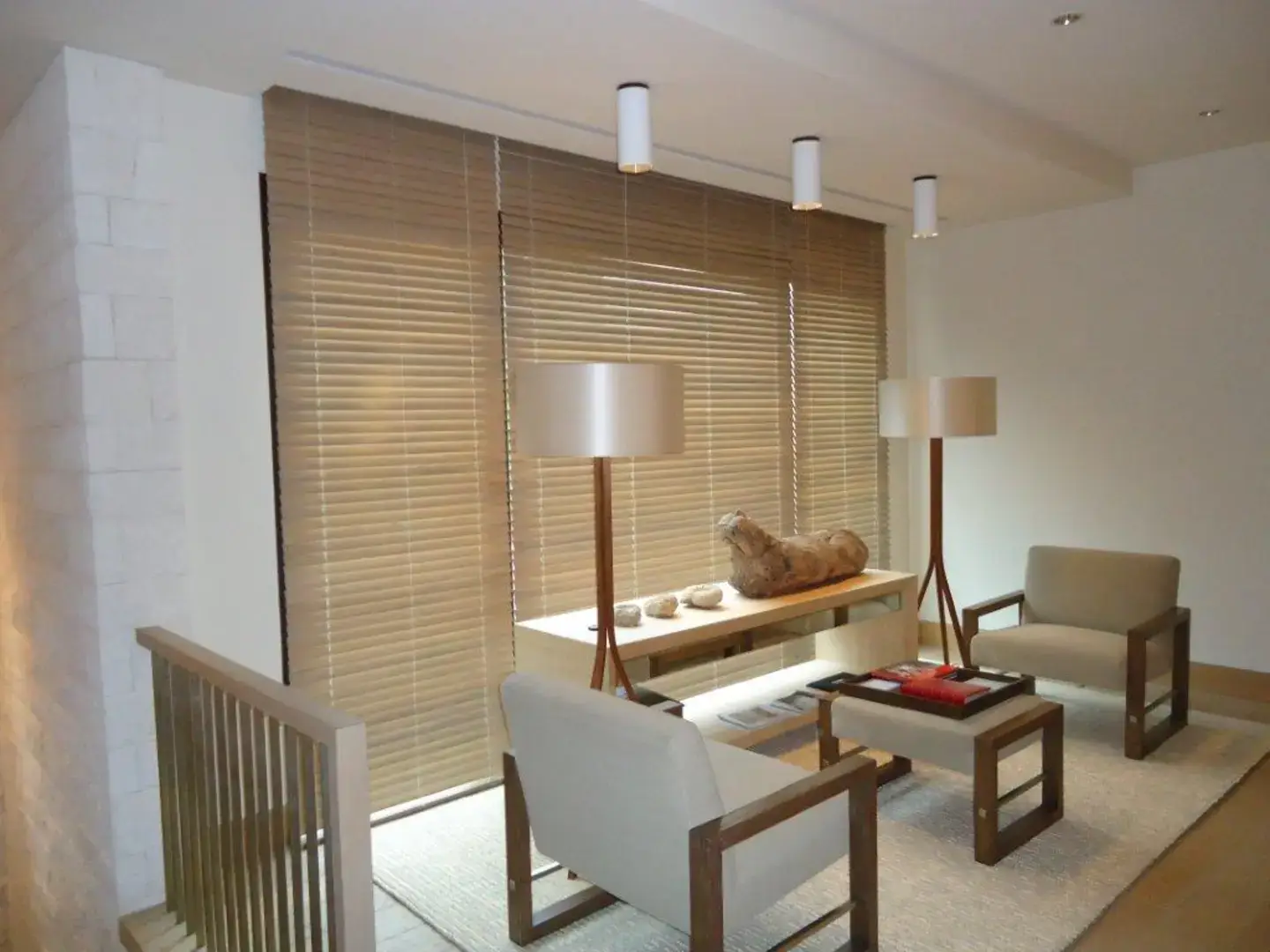 Custom wooden blinds in the living room of a modern, luxurious home.