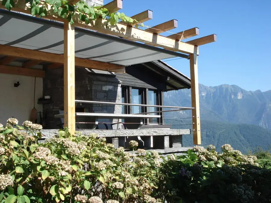 Custom patio shading structure on a home with a mountain view in the background.