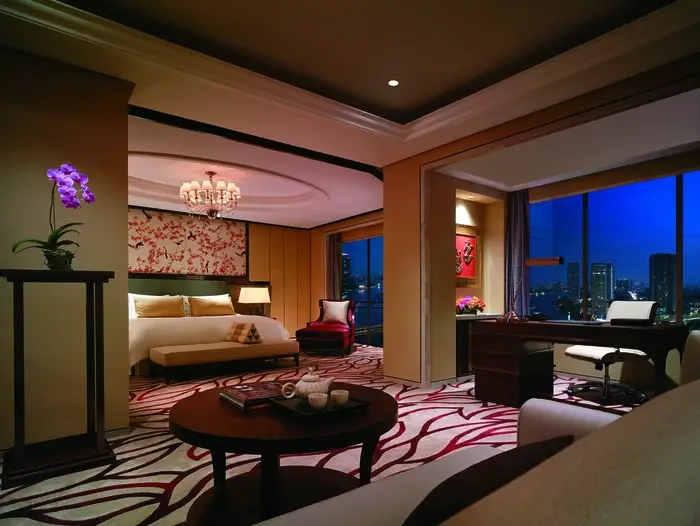 Low-lit bedroom at the Shangri-La Hotel with custom drapes providing privacy and ambiance.