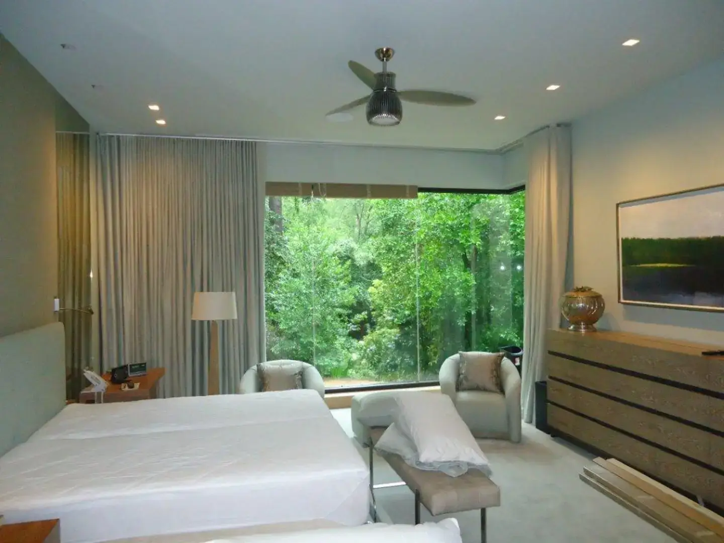 Drapery and custom wooden blinds combination in a bedroom of a home.